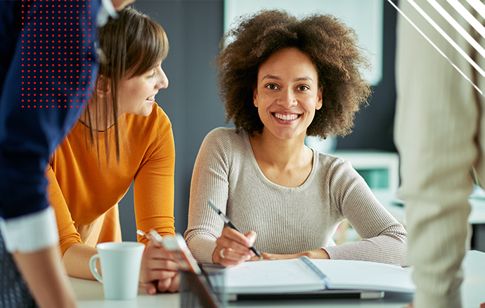 Smiling woman looking at the camera holding a pen