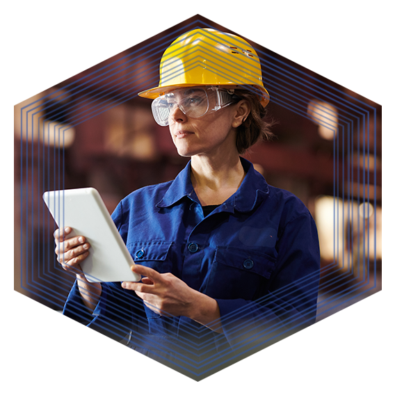 Woman wearing a yellow hard hat and safety glasses holding a tablet