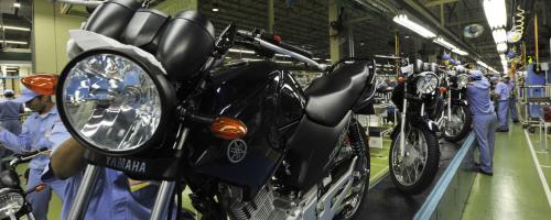 Yamaha motorcycle inside factory with factory workers in safety gear